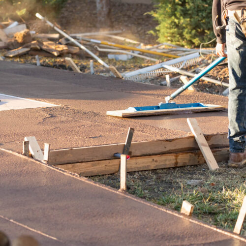 Construction Worker Smoothing Wet Cement With Trowel Tool