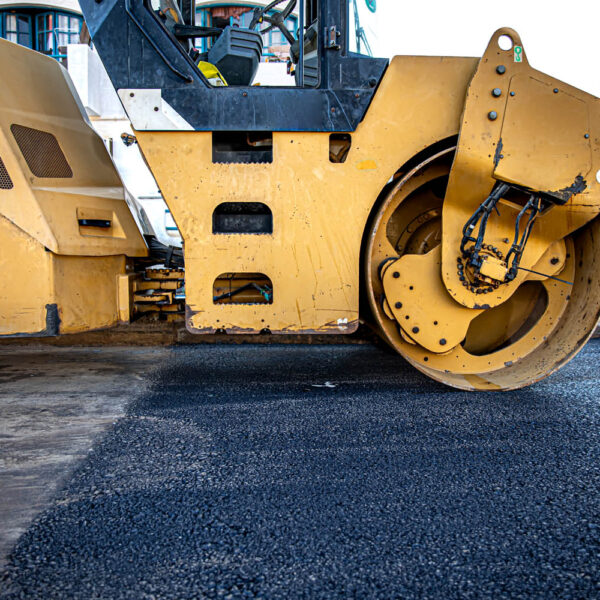 Road roller makes the paving. Road roller compacting asphalt. Roller Compactor on Fresh Asphalt.